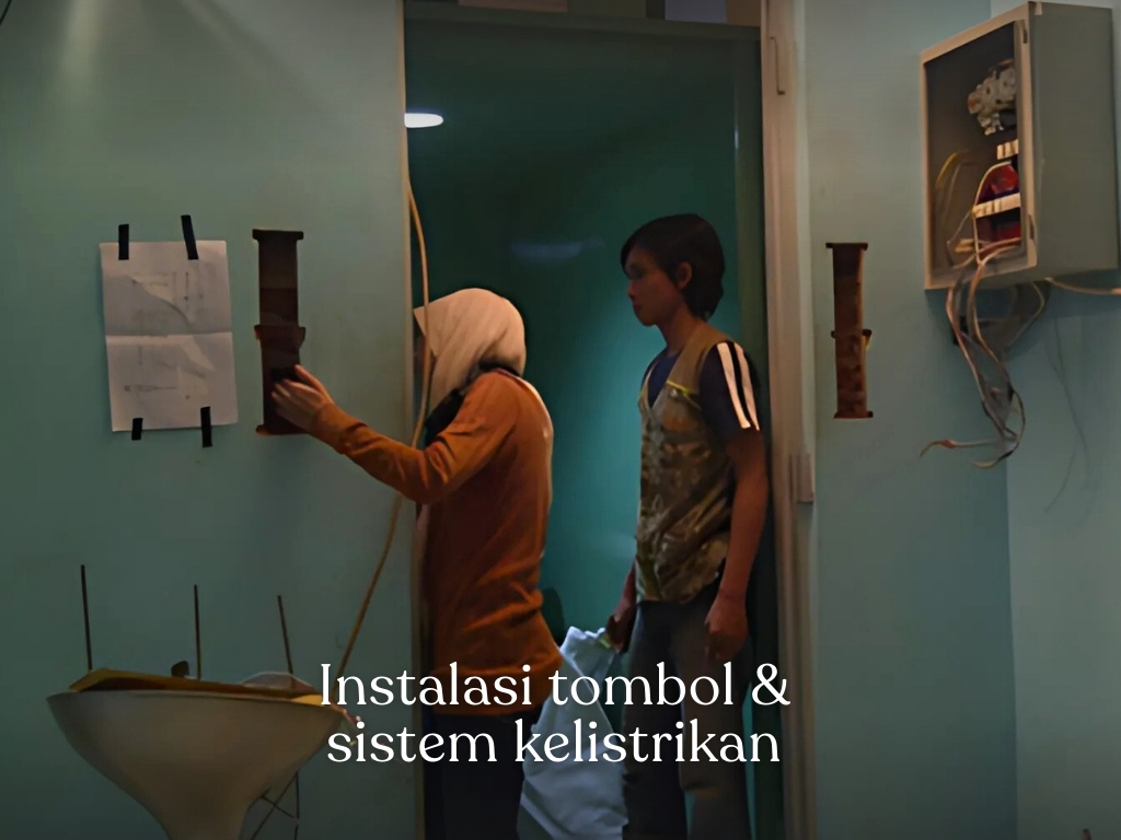 teknisi memasang tombol dan sistem kelistrikan lift barang industri